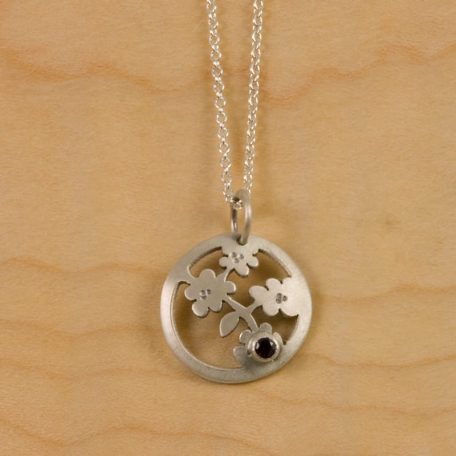A Nara Blossom Pendant adorned with a striking black stone.