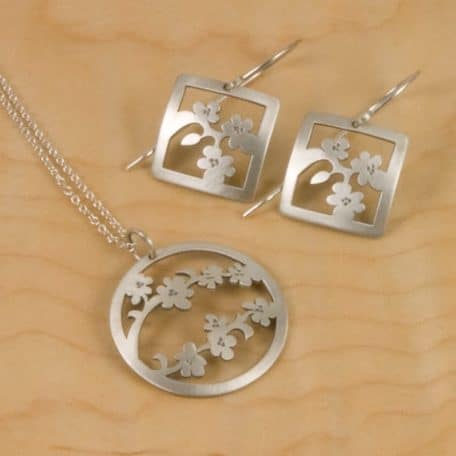A pair of silver earrings featuring the Sendai Blossom Pendant.