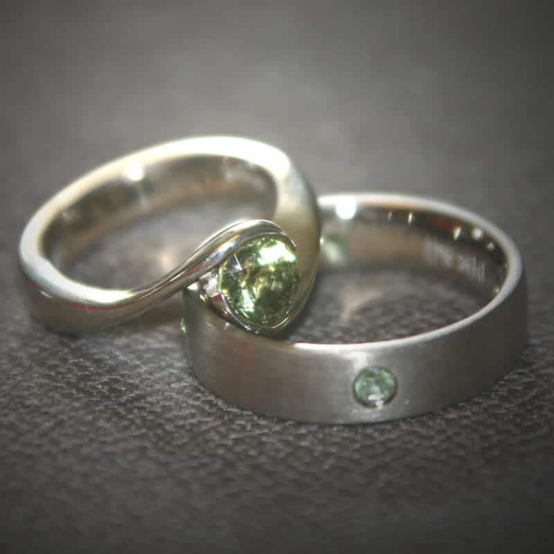 Custom wedding rings with green sapphires.