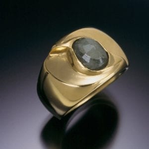 A custom gold ring with a black stone.