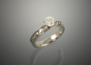 A custom white gold ring with a diamond in the center.