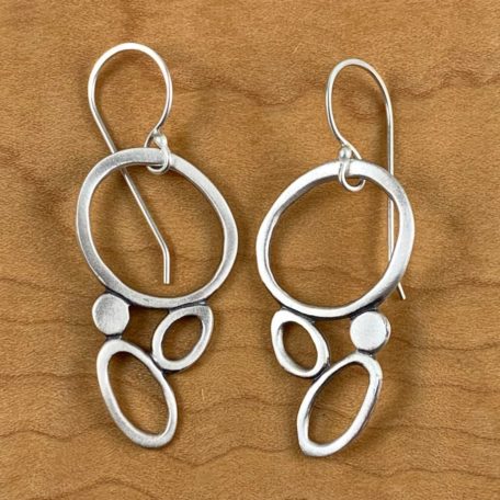 A pair of Sea Foam Earrings on a rustic surface.