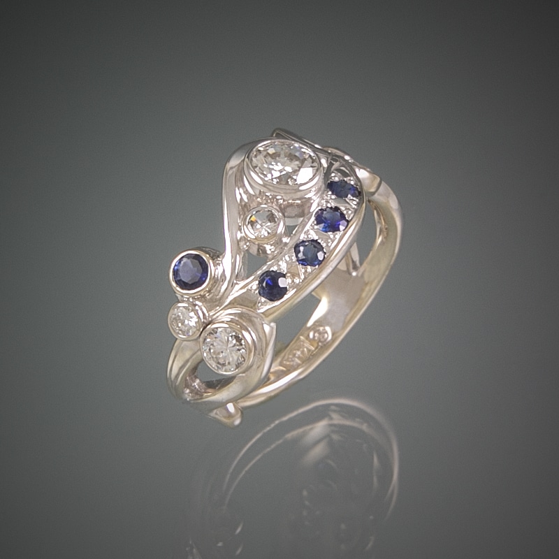 A custom white gold ring with blue sapphires and diamonds.