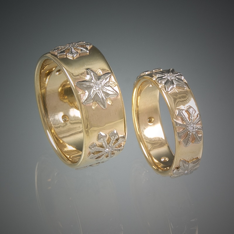 A pair of custom gold wedding rings with a flower design.