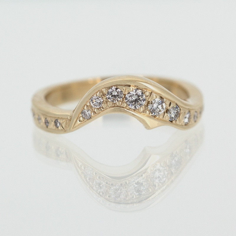 A custom yellow gold ring adorned with diamonds.